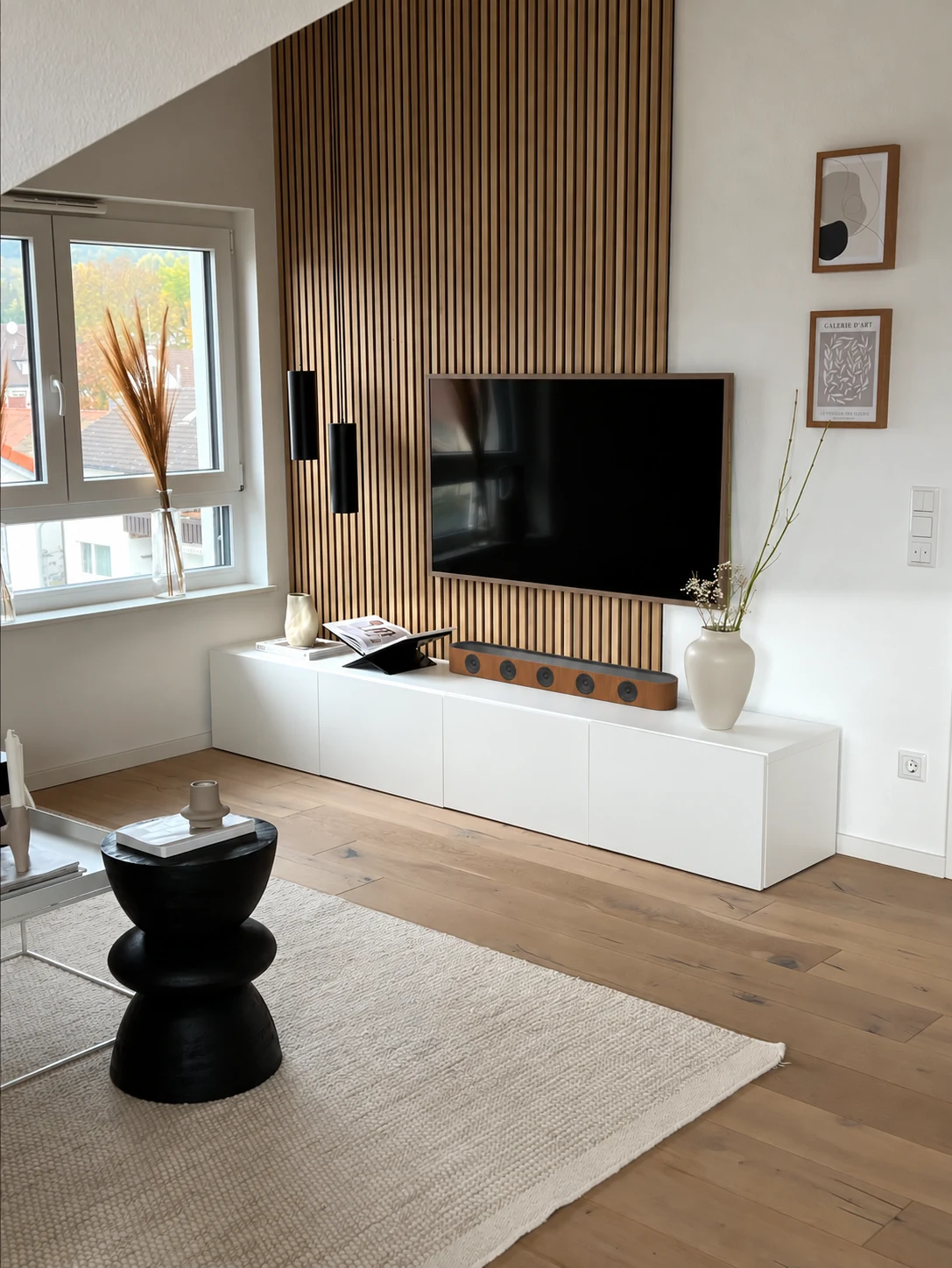 Timber soundbar on a white media cabinet beneath a television in a living room