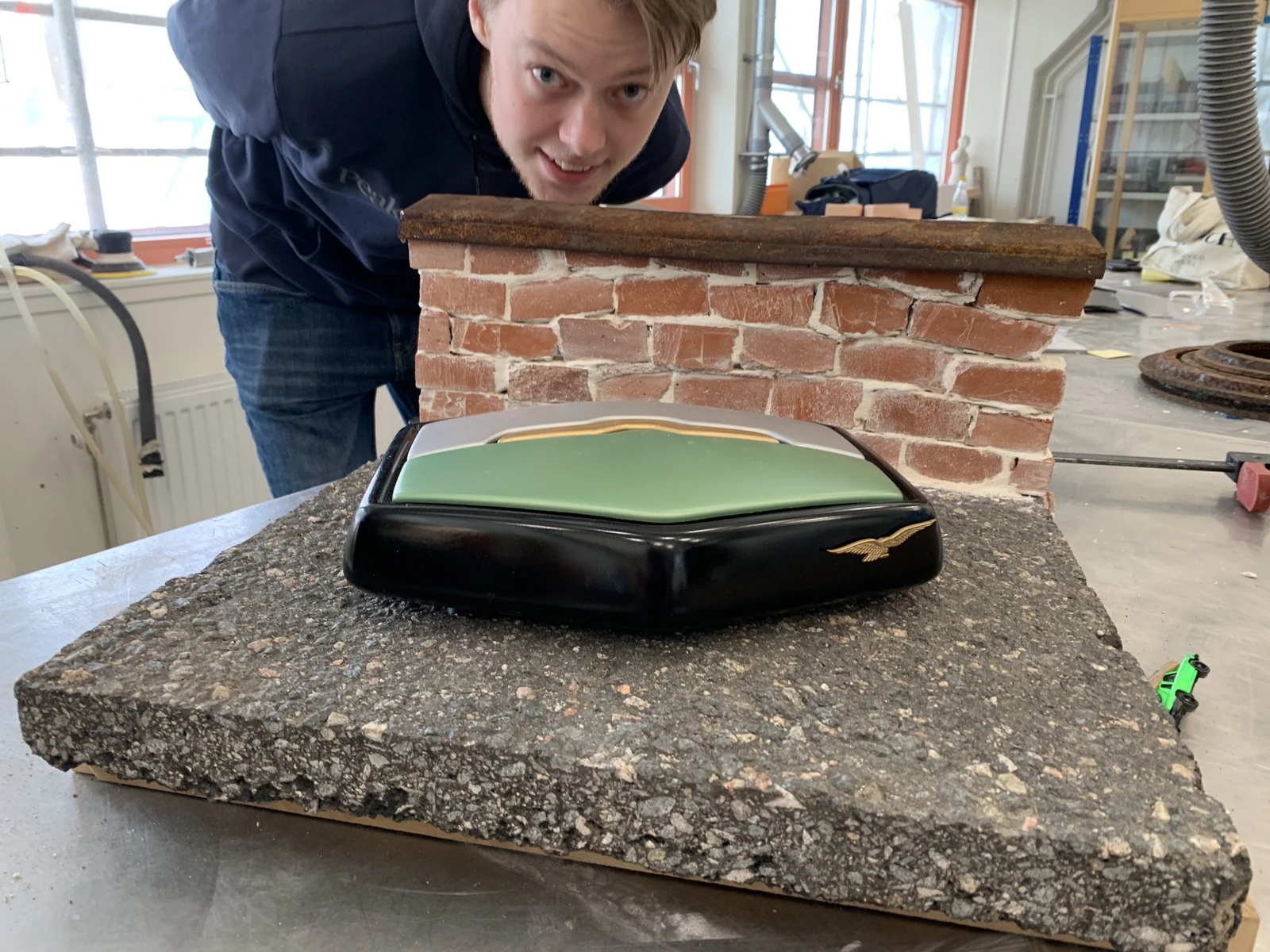 Building a display stand with a textured base and brick backdrop for the Moto Guzzi robot vacuum prototype