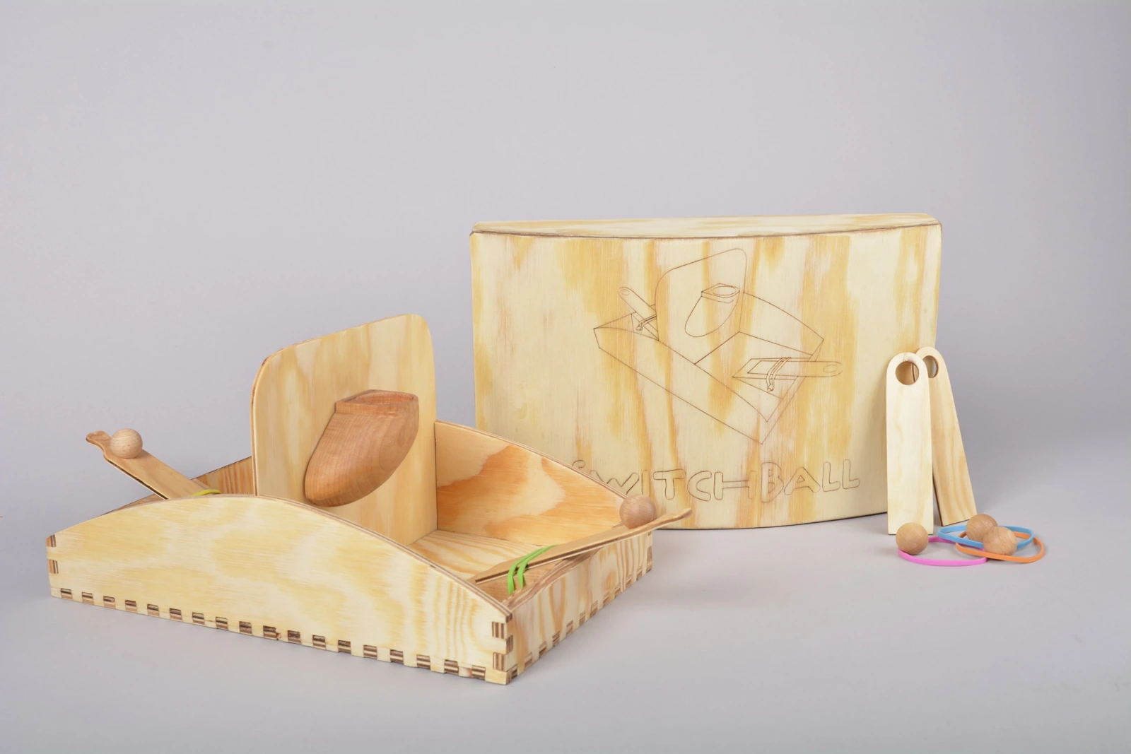 A wooden tabletop game with rubber-band launchers